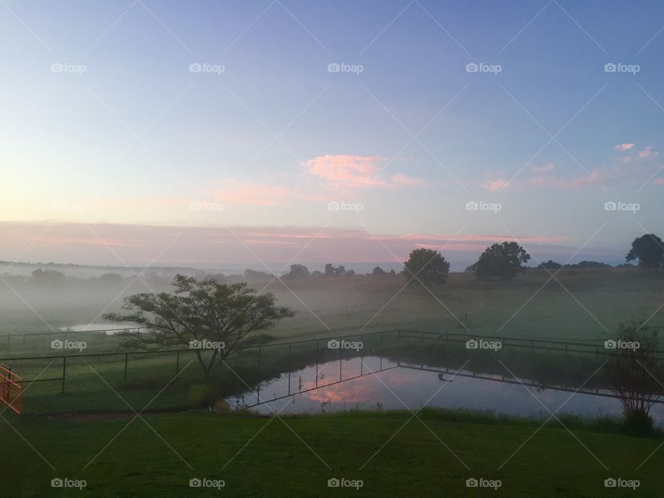 Foggy sunrise over farm pond