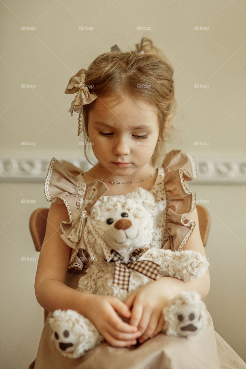 Vintage portrait of a beautiful little girl with teddy bear 