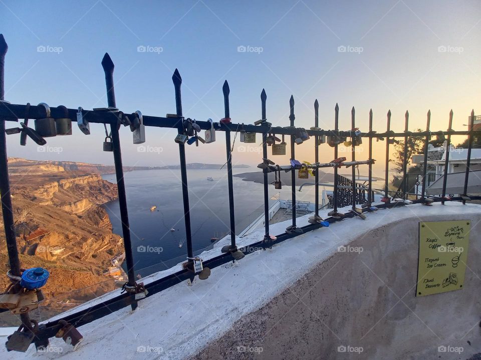 On the top of Thira, Santorini, there is a place where couples lock their love in these little locket with background the romantic view of Caldera.