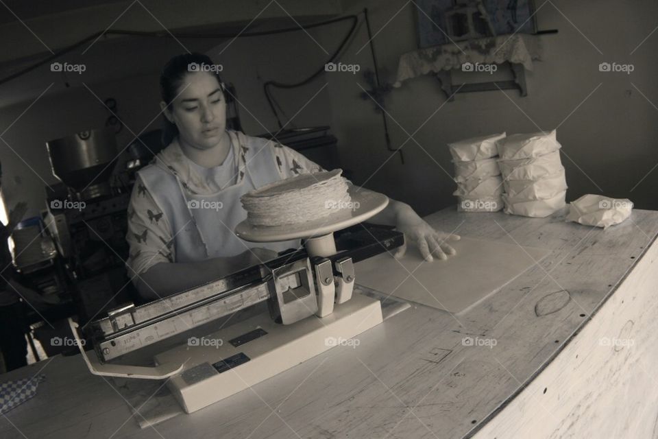 Mexican pueblo senorita making tortillas