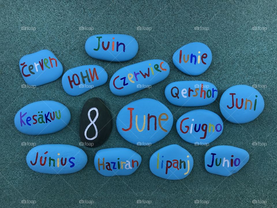 8 June, calendar date with colored stones over green sand