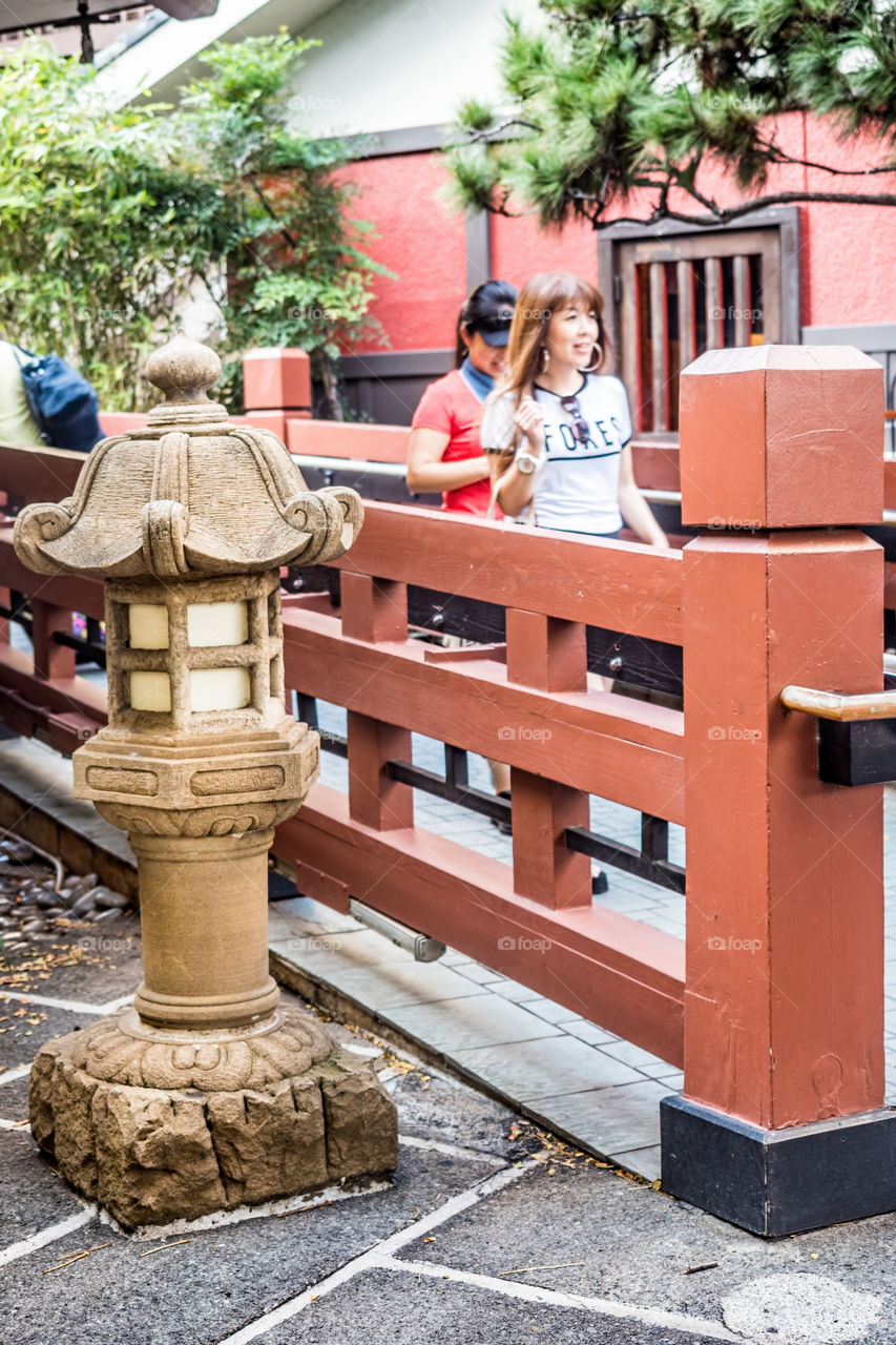 Waikiki, Honolulu, Hawaii, USA - December 13, 2015: Japanese-style stone lantern and walkway in the Hilton Hawaiian Village. This path is frequented by hundreds of visitors daily, with many high-end branded shops around this area. It's a shopping haven.