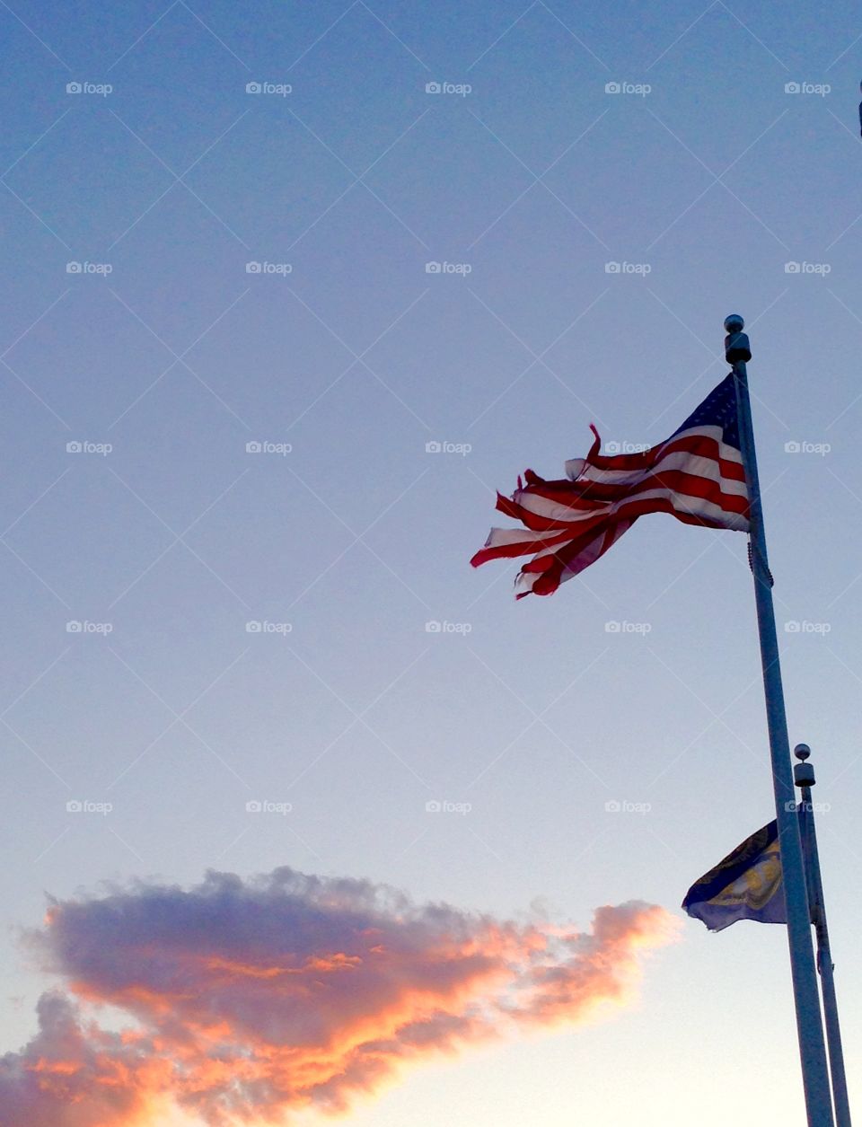 Tattered American flag at sunset