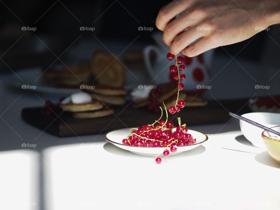 Unidentified man's hand holds a bunch of red currants on a sunny day, food, still life concept 