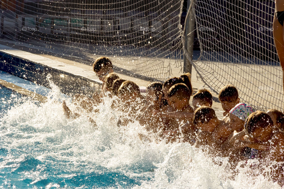 Children learn to swim in the pool, leg workout exercises