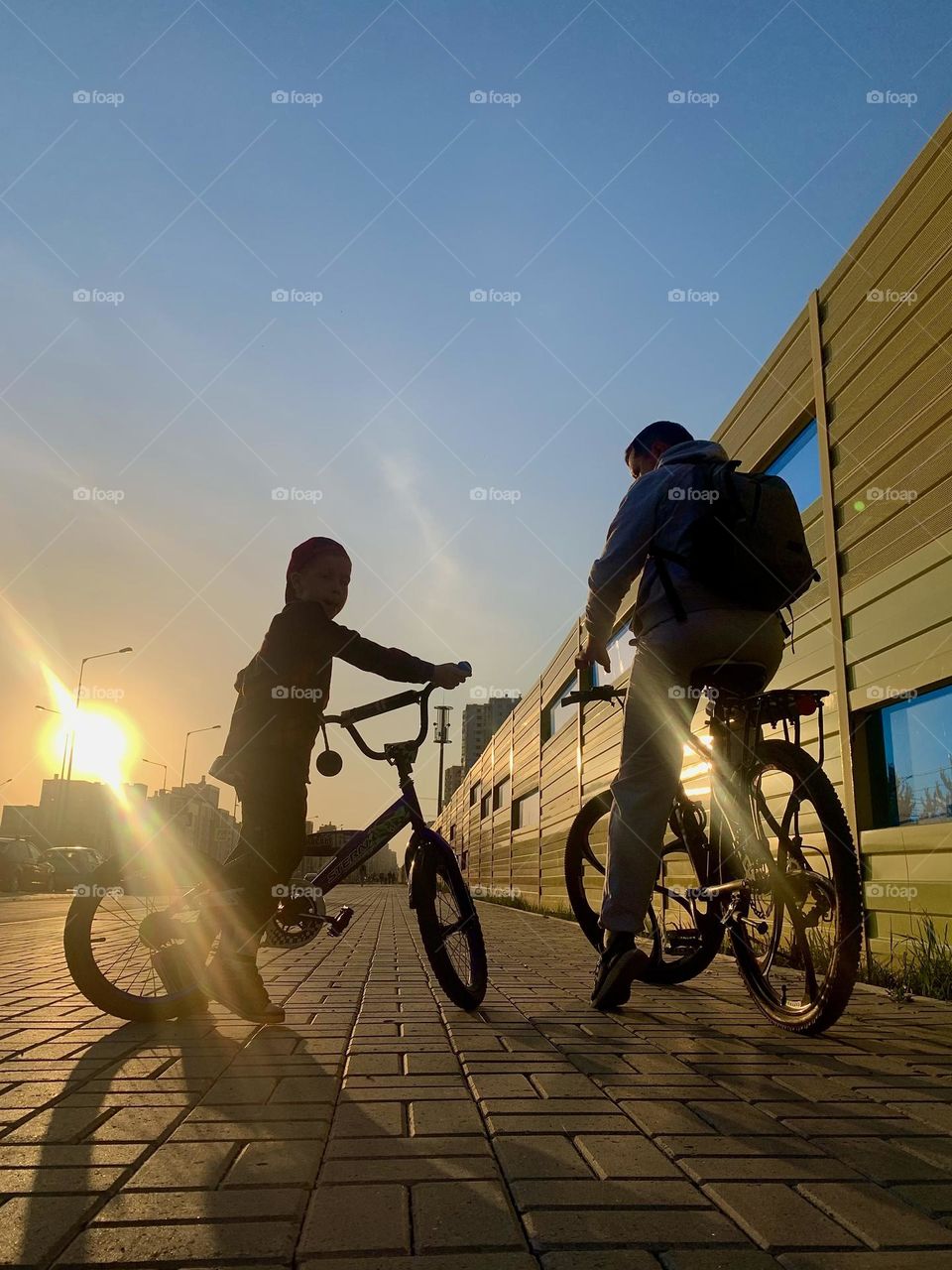 Father and son on bikes at sunset