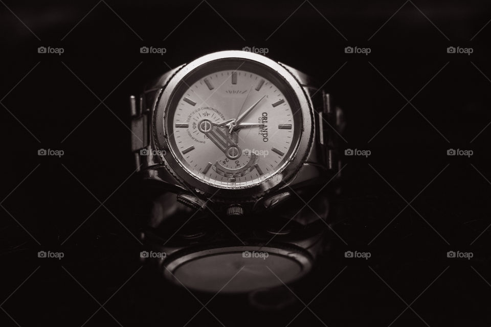 A product photography of an Orlando watch with a black background and a reflection.