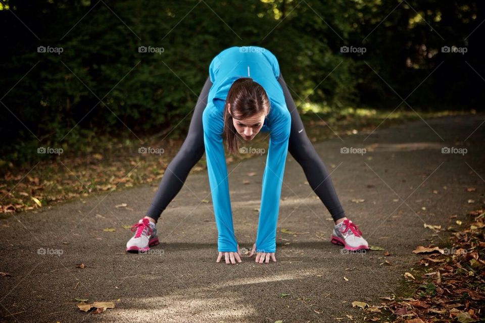 Young woman stretching and preparing to go running on a near by