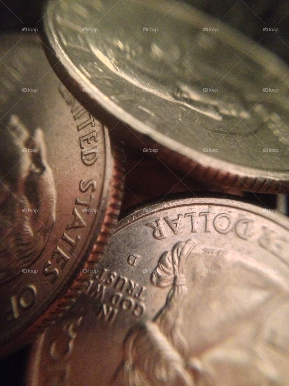 Close up macro shot of 3 coins stacked in a spiral.