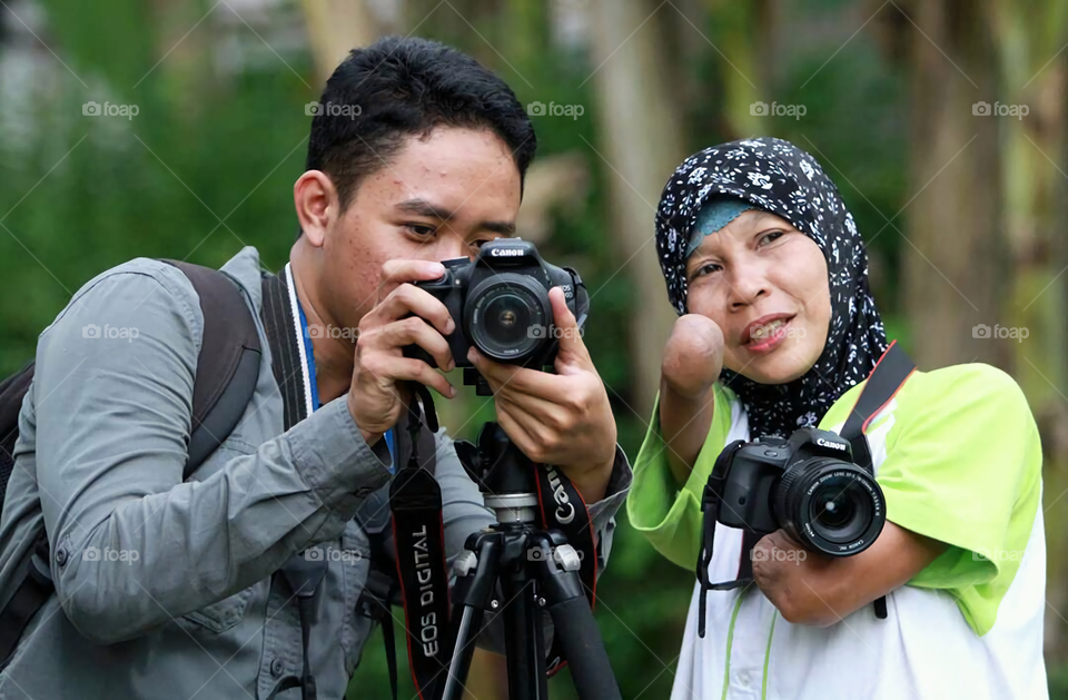 Man and disable woman photographing through camera