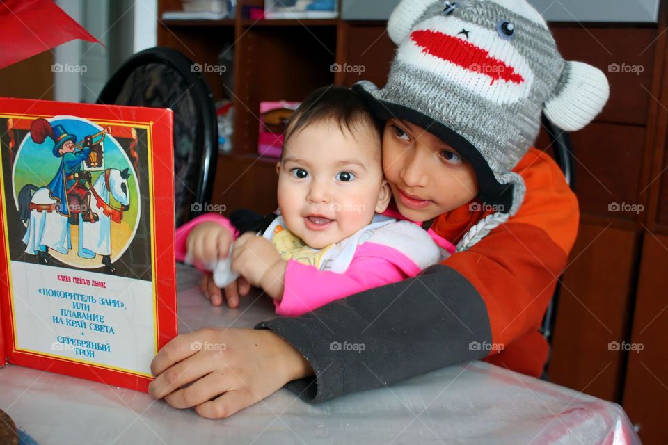 Cute siblings are reading a book