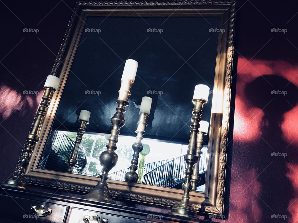 The mirror in the hall with the white candles with the  metallic design of all time. 