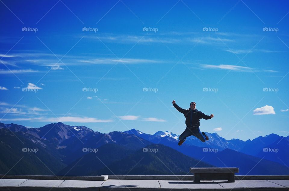Happy man jumping against blue sky