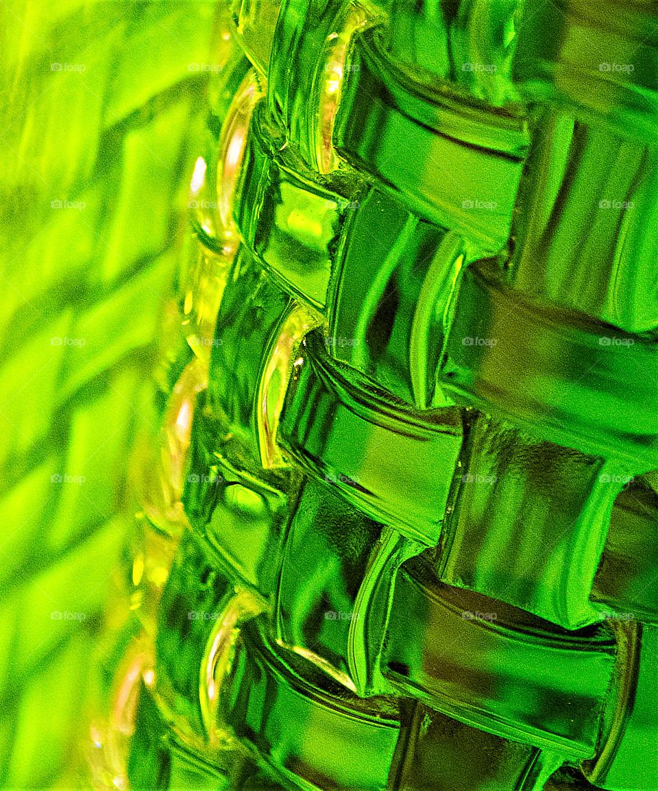 Rectangles, square shapes, Glass filled with green liquid reflecting green shadow onto the wall 