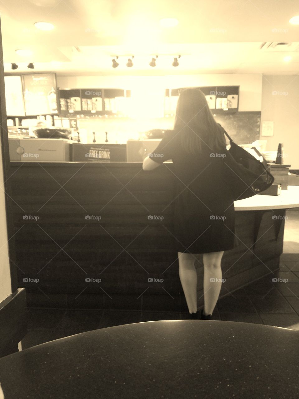 Girl Waiting For Drink at Starbucks in Manhattan. Sepia Filter. Taken on Galaxy S7 Android Phone. June 2017.