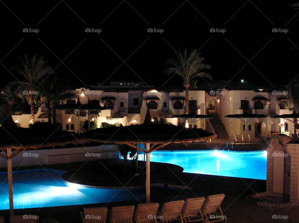 Territory of a hotel in the night with illuminated pools