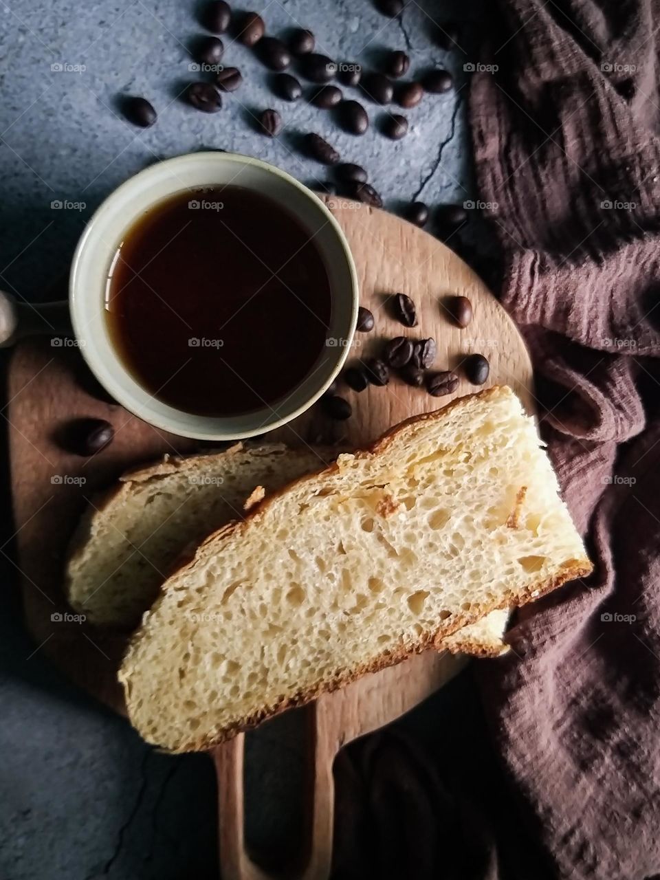 bread and black hot coffee on a wooden board