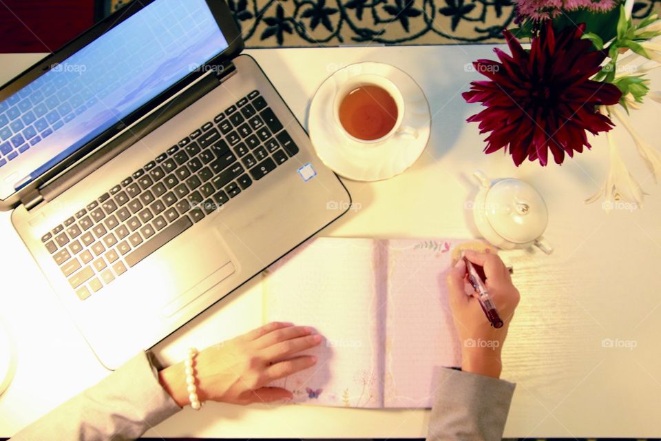 Flat lay woman working at desk with laptop and tea