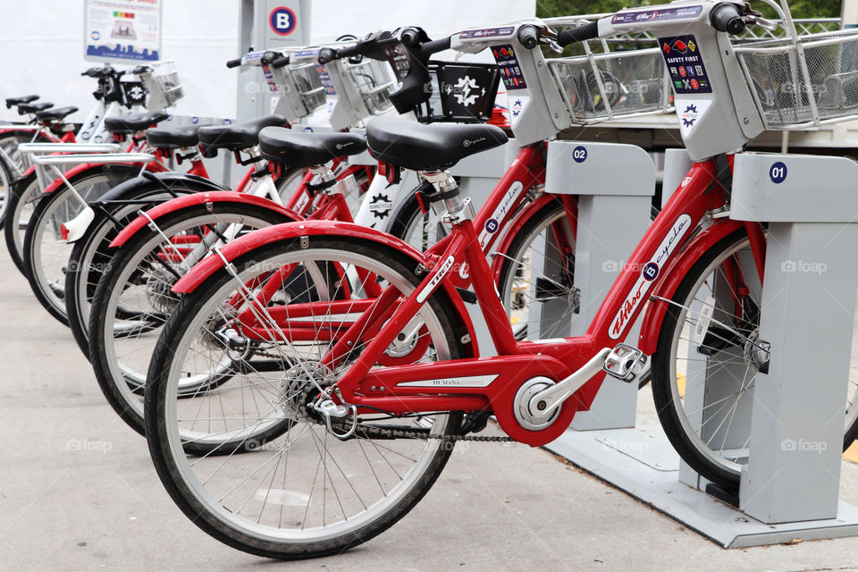 Row of bright red bikes on a stand downtown