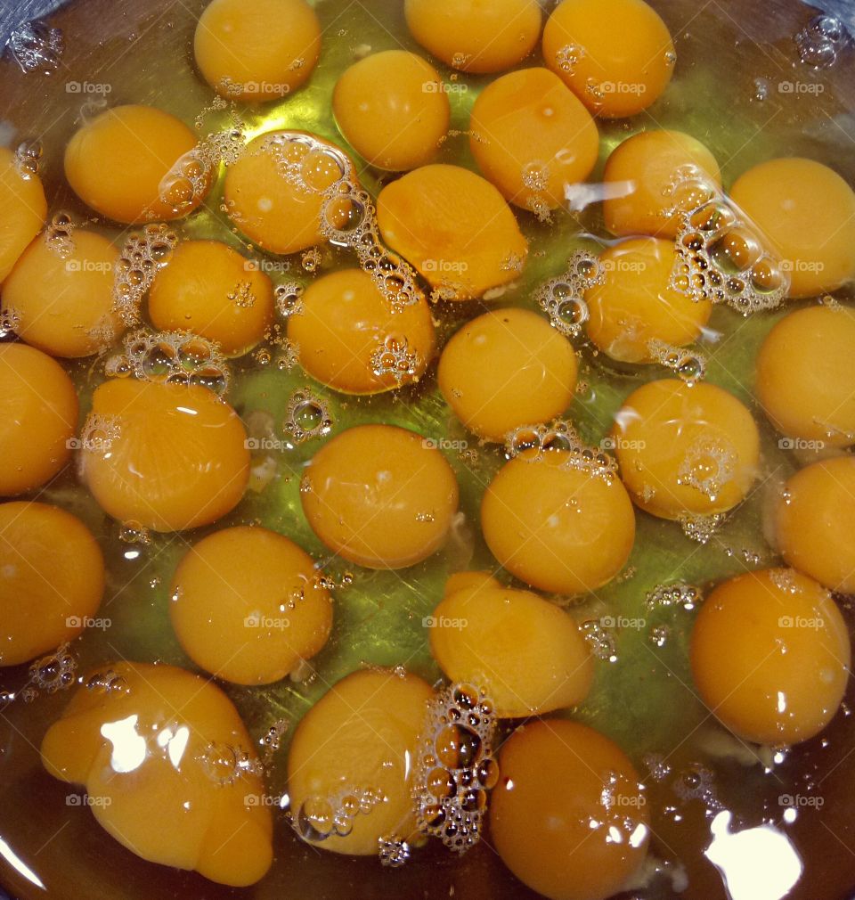 38 bright yellow, free range eggs cracked into a Stainless Steel mixing bowl.