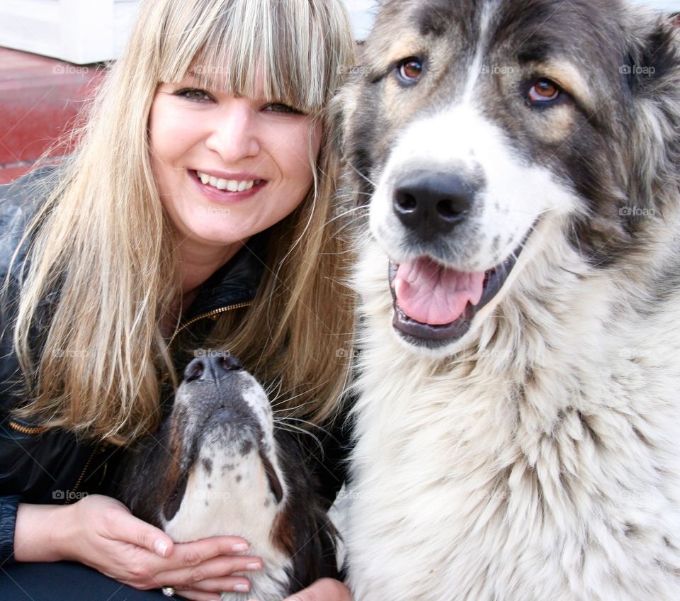 Happy smiling blond with two big dogs 