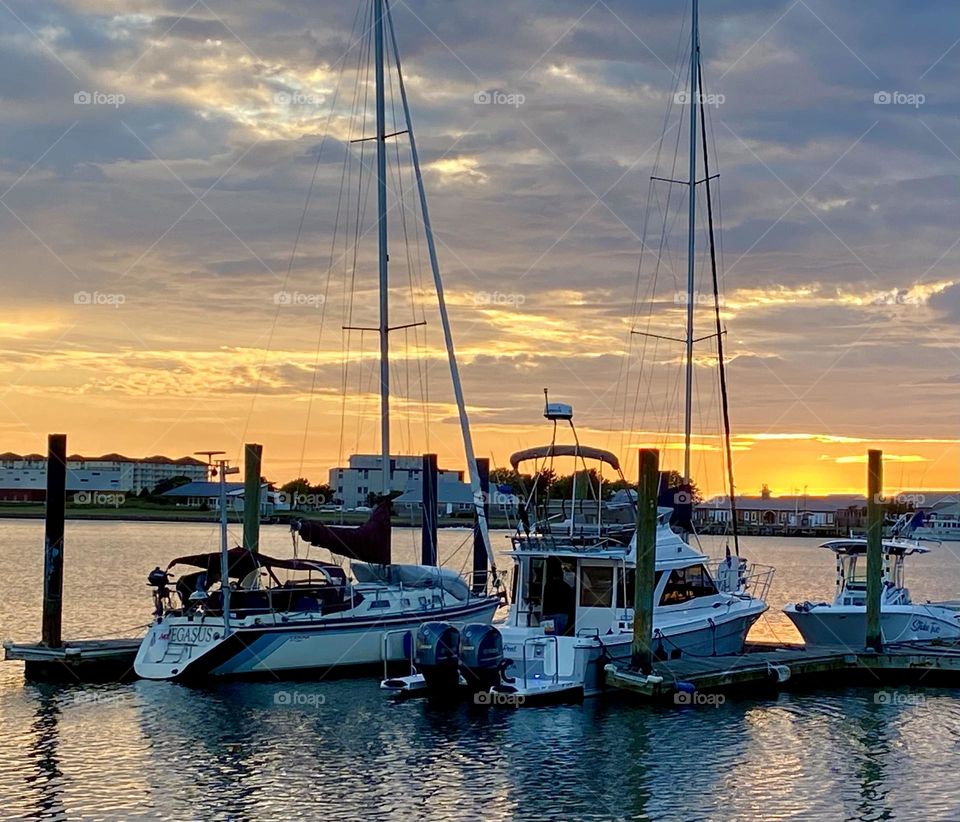 Sailboats docked at sunset 