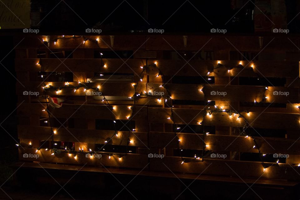 The word bar is illuminated with Christmas lights at an outdoor reception