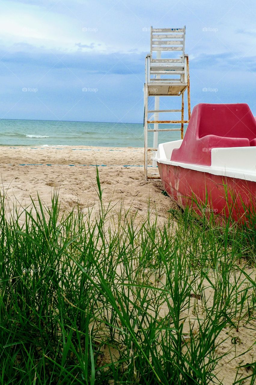 at the beach. with a red boat and a
