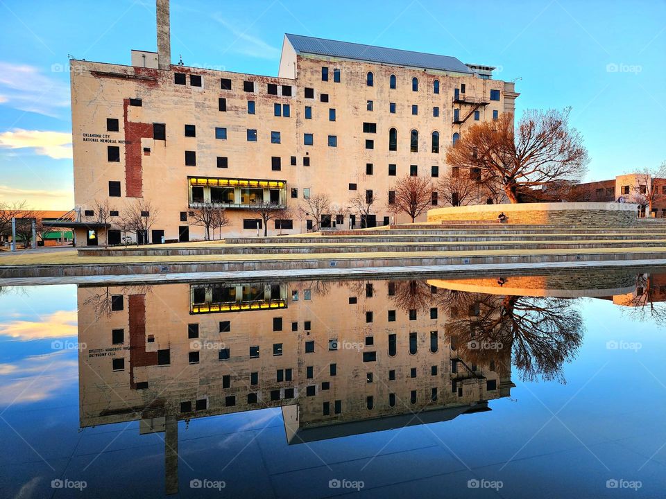 The Oklahoma City Bombing Memorial building is a mirror image in the reflecting pool out front on a calm evening