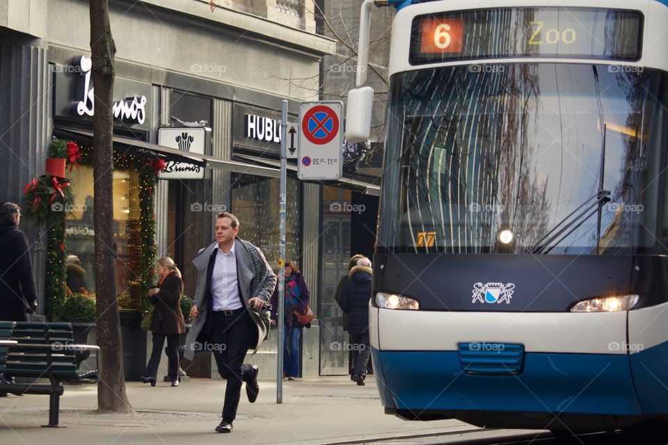 Street Shot Of Commuter Running To Catch A Tram In Zürich