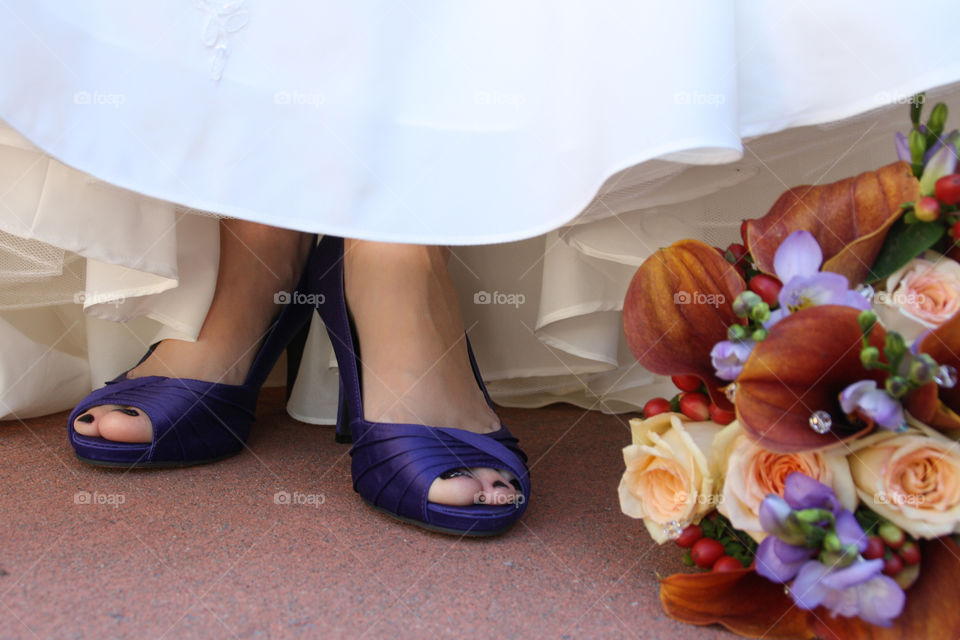 A. Rides feet and deep purple shoes with her colourful bouquet