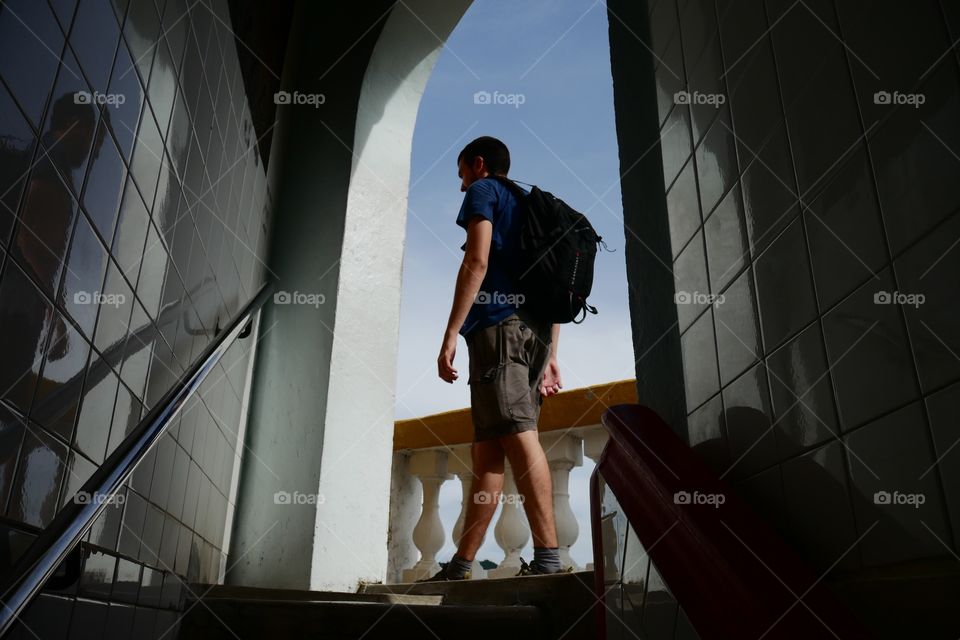 The boy is walking trough a door of the ancient pagoda of Kuala Lumpur 