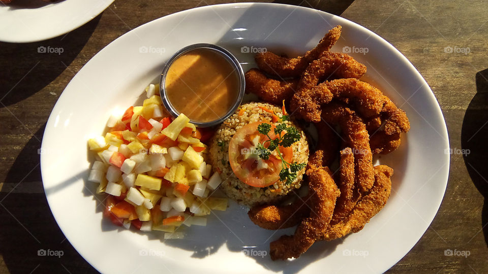 Tropical meal. Shrimps in tempura with fruit salad