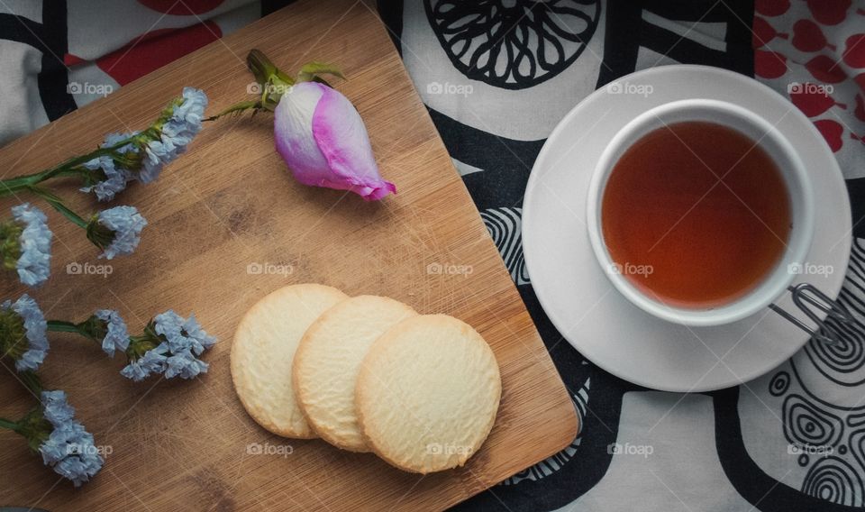 three pieces of biscuits in flowers with tea