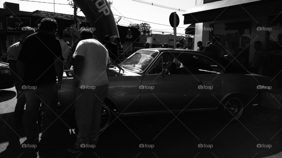 Homens analizando motor de Opala.