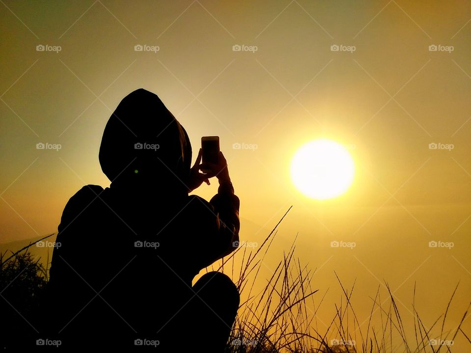 someone who is photographing the sunrise