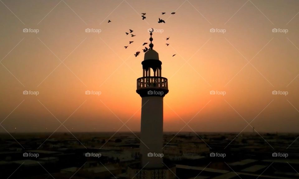 Sunset through the silhouette of a tower