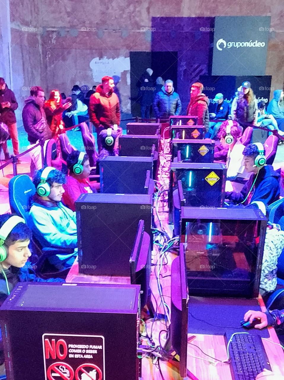 juegos en red máquinas y adolescente jugando todos a la vez en un evento gamers