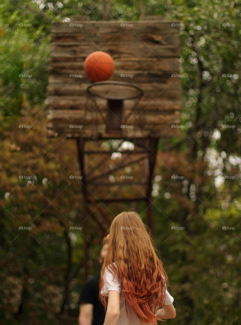 Girl playing basketball in her yard