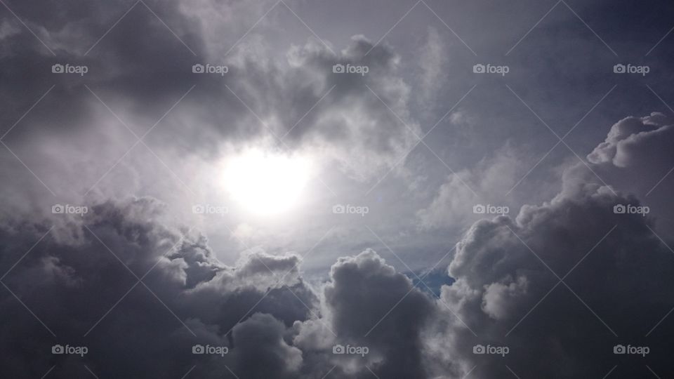 sun shows behind stormy clouds