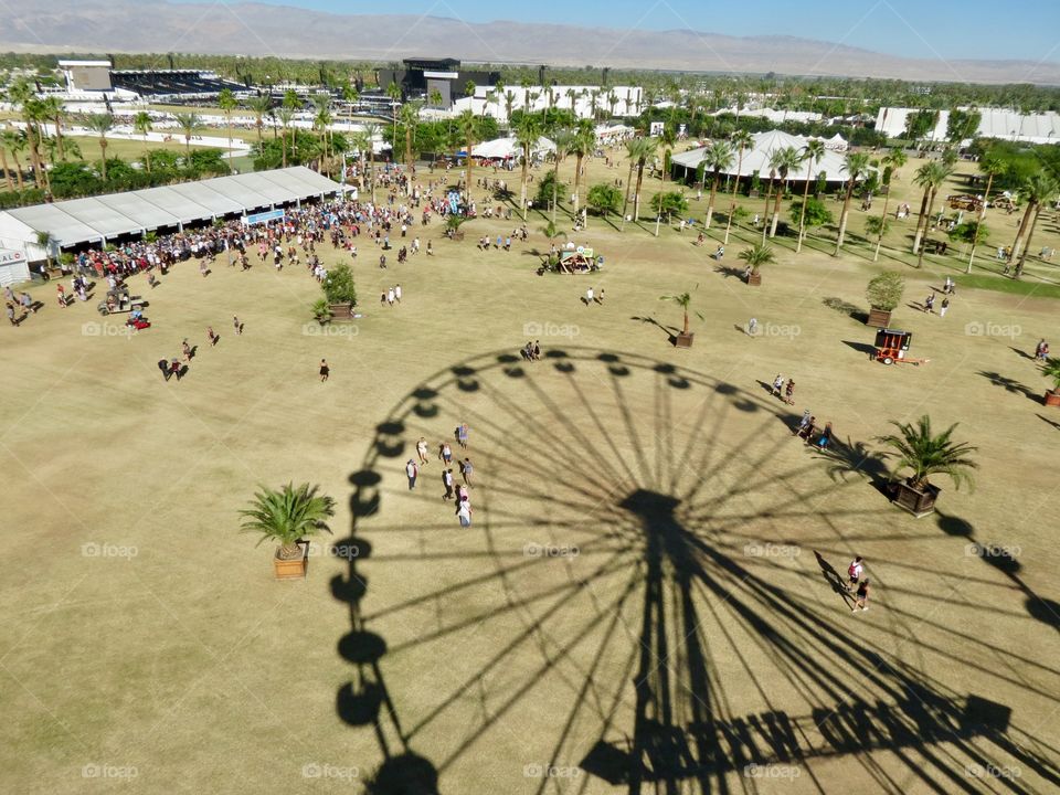 Shadow of Ferris wheel on fair grounds.