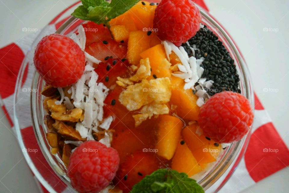 Smoothie fresh fruits bowl - peach, raspberry,  almonds,  strawberries,  coconut,  honey,  seeds and mints