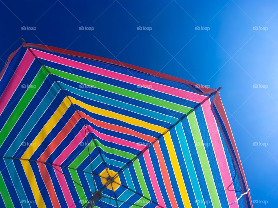 Colorful umbrella against blue sky