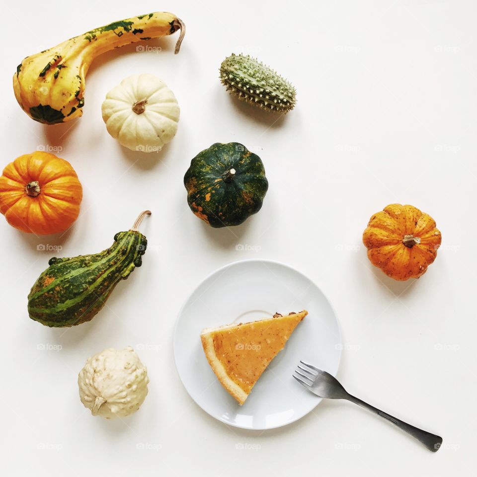 pumpkin pie on an autumn table with flat lay pumpkins