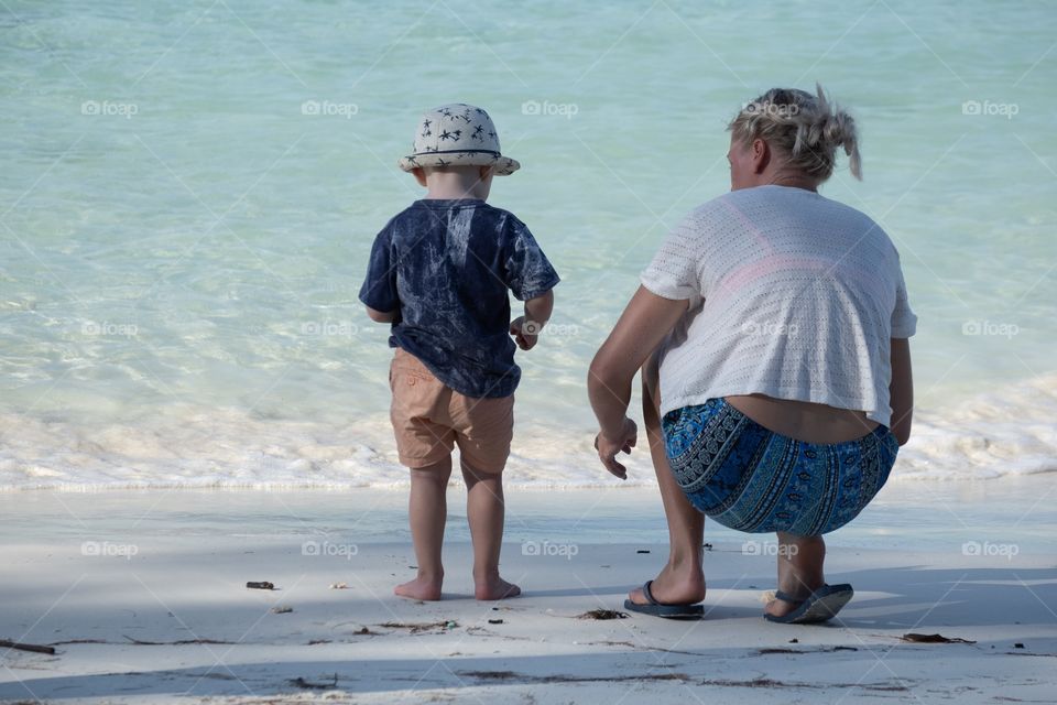 Tourist and her kid enjoy their summer on the beautiful beach