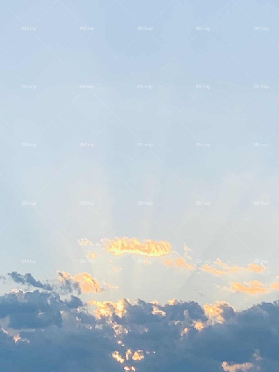 Beautiful blue and gold sky with visible rays of the sun in late summer