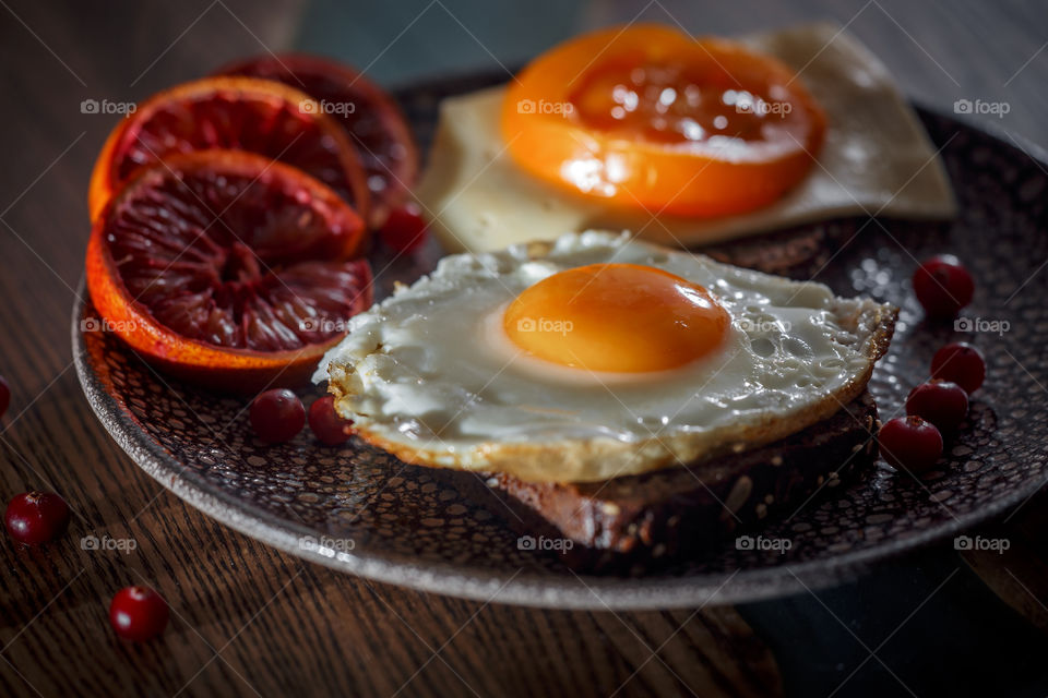 Sandwiches with fried egg orange tomato and red orange fruit 