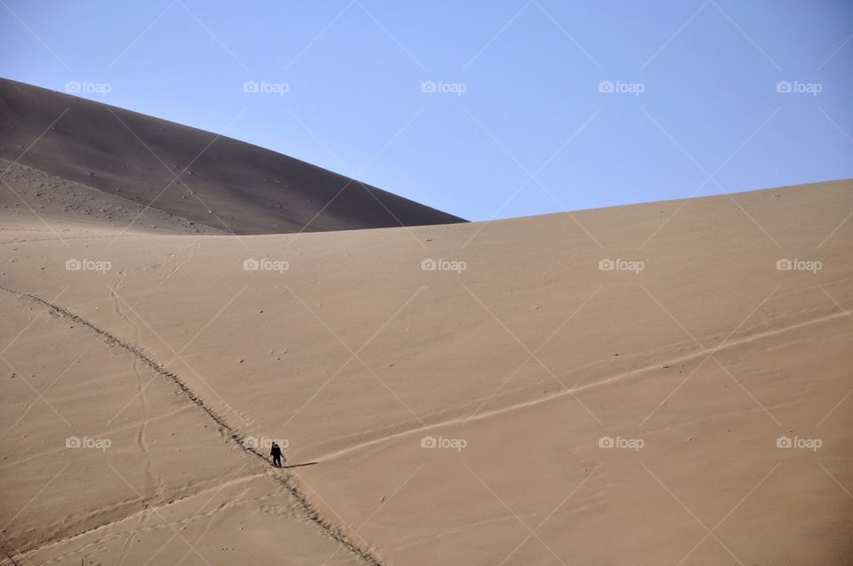Man walking on dunes, ica, peru