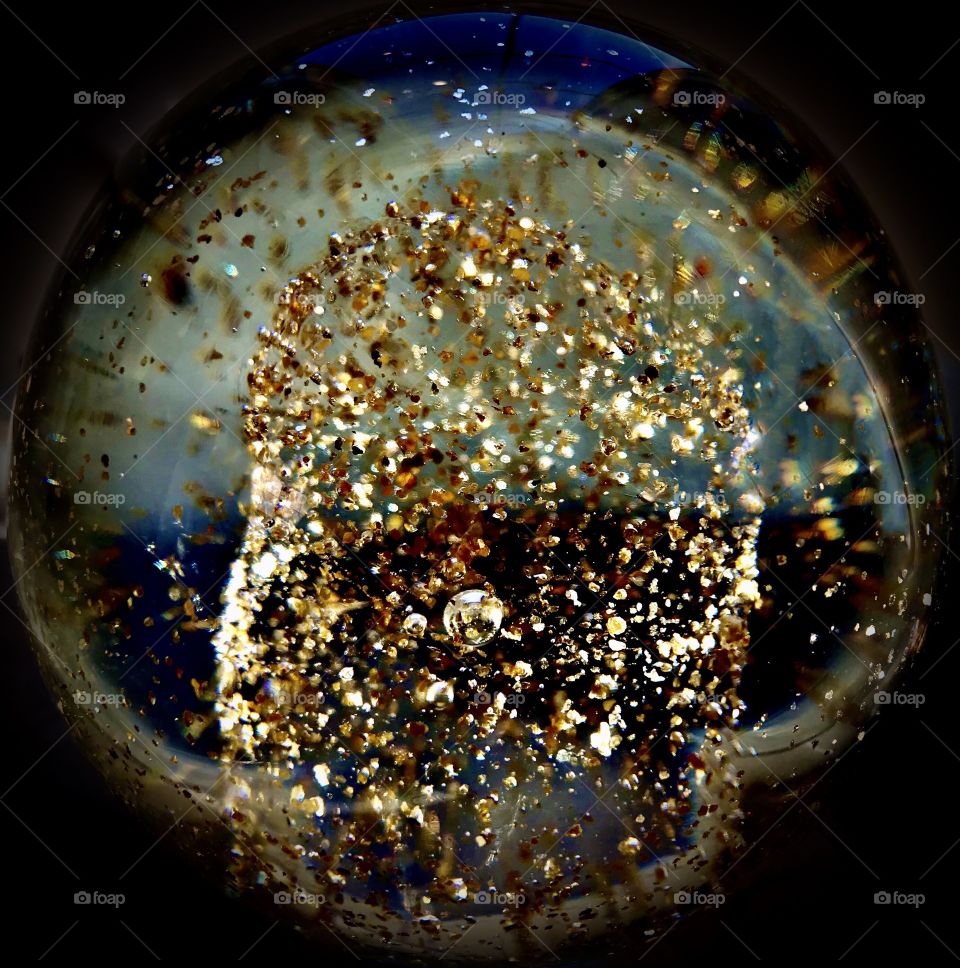 Flakes of gold in crystal sphere 