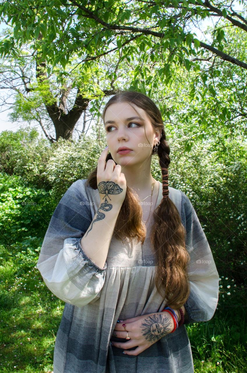 Portrait of Young Girl on Background of Flowers